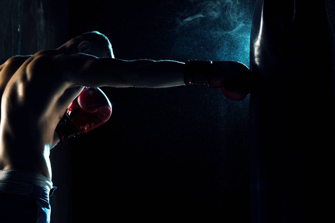 male-boxer-boxing-in-punching-bag-PYLYEXL-scaled.jpg